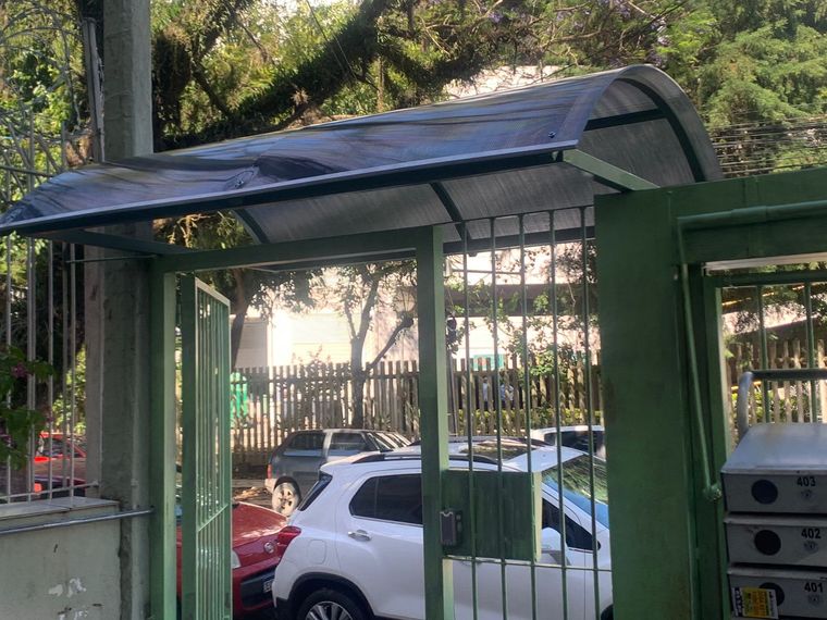 Toldo curvo sobre portão de entrada